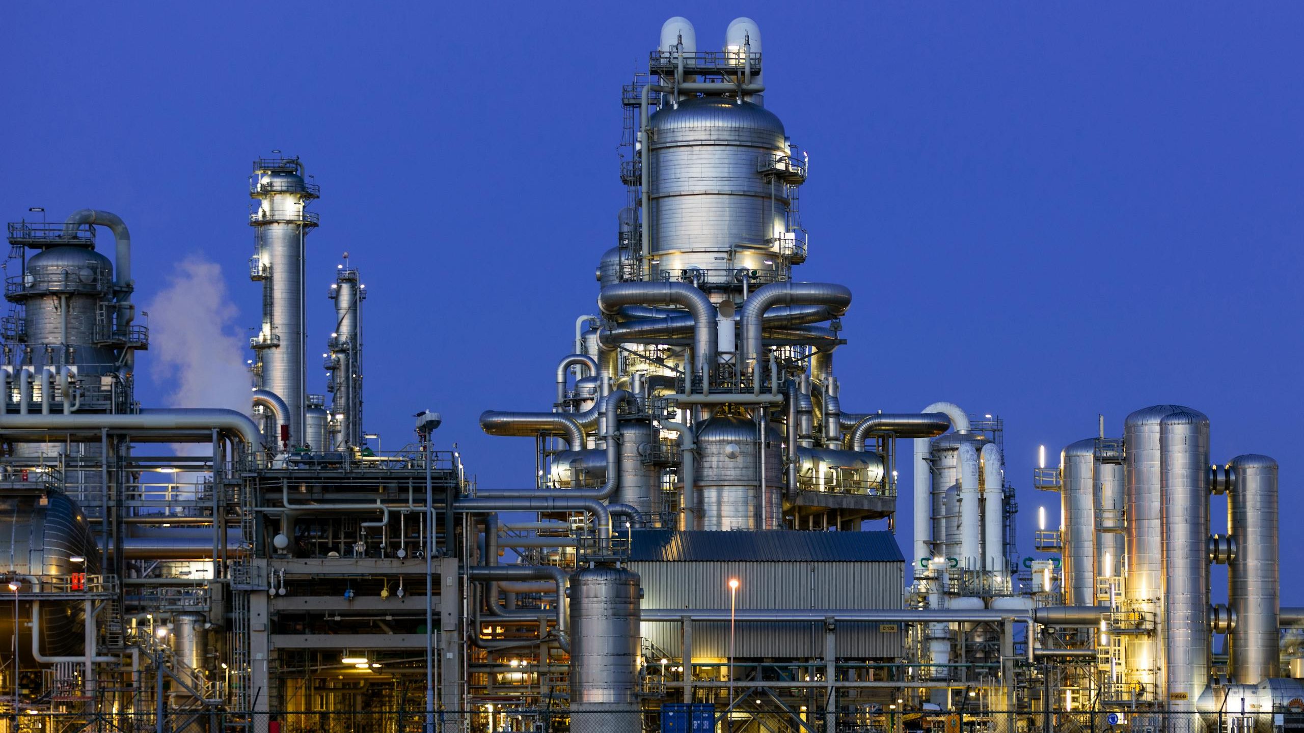A modern industrial refinery structure under a clear twilight sky in Zuid-Holland, Netherlands.